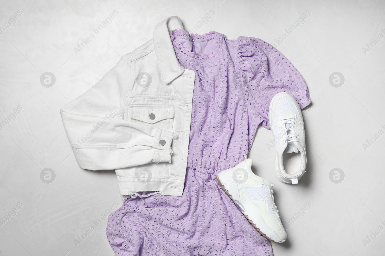 Photo of Stylish violet dress, white jacket and shoes on light background, flat lay