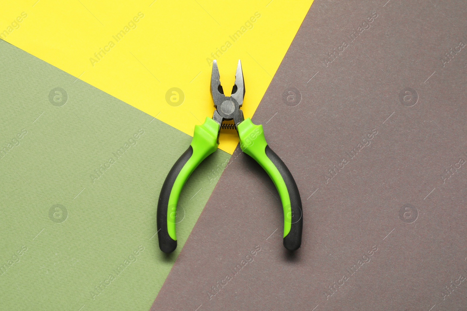 Photo of Combination pliers on color background, top view