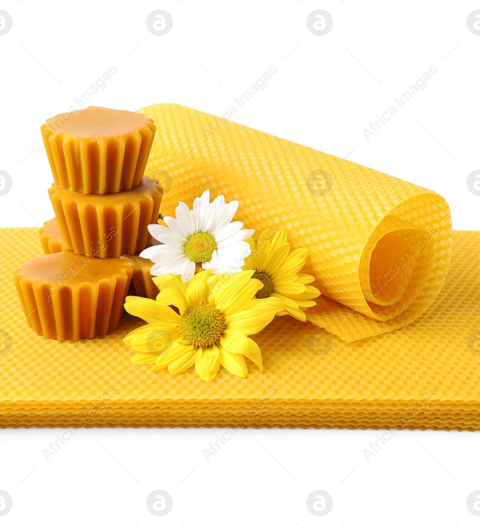 Photo of Natural beeswax cake blocks, flowers and sheets on white background