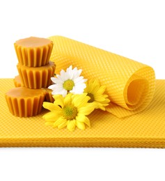 Natural beeswax cake blocks, flowers and sheets on white background