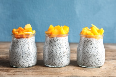 Jars of tasty chia seed pudding with persimmon on table