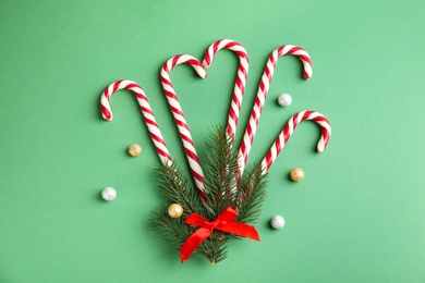 Photo of Candy canes on green background, flat lay