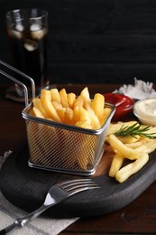Photo of Tasty french fries and dip sauces served on wooden table