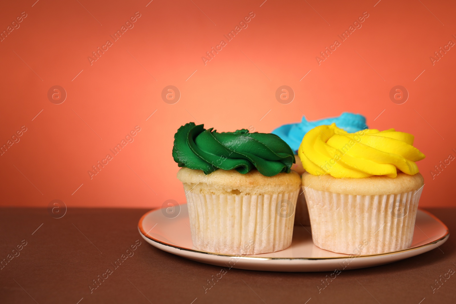 Photo of Delicious cupcakes with bright cream on color background, space for text