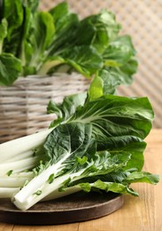 Leaves of fresh green pak choy cabbage on wooden table, closeup