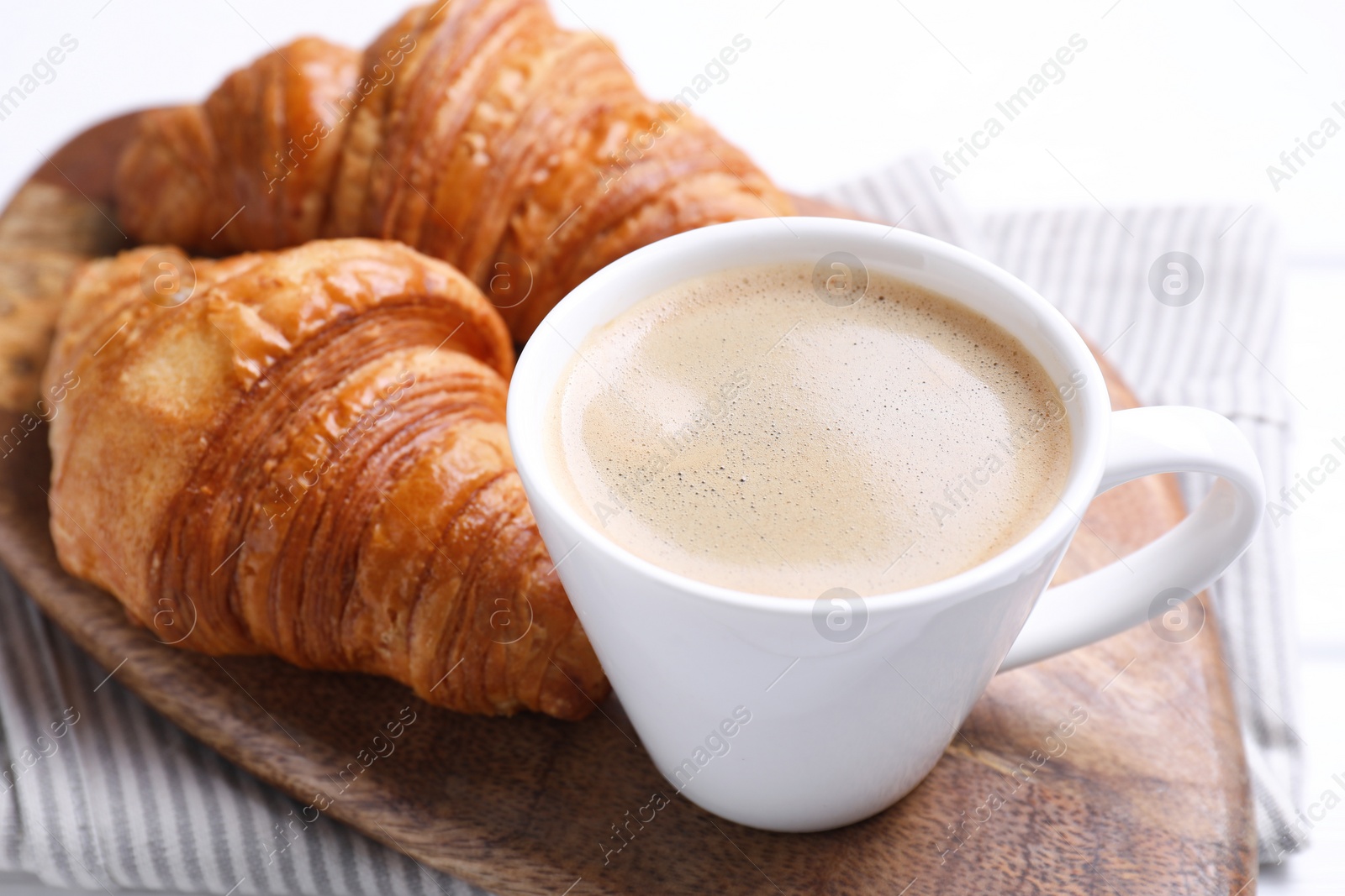 Photo of Tasty breakfast. Cup of coffee and croissants on table, closeup