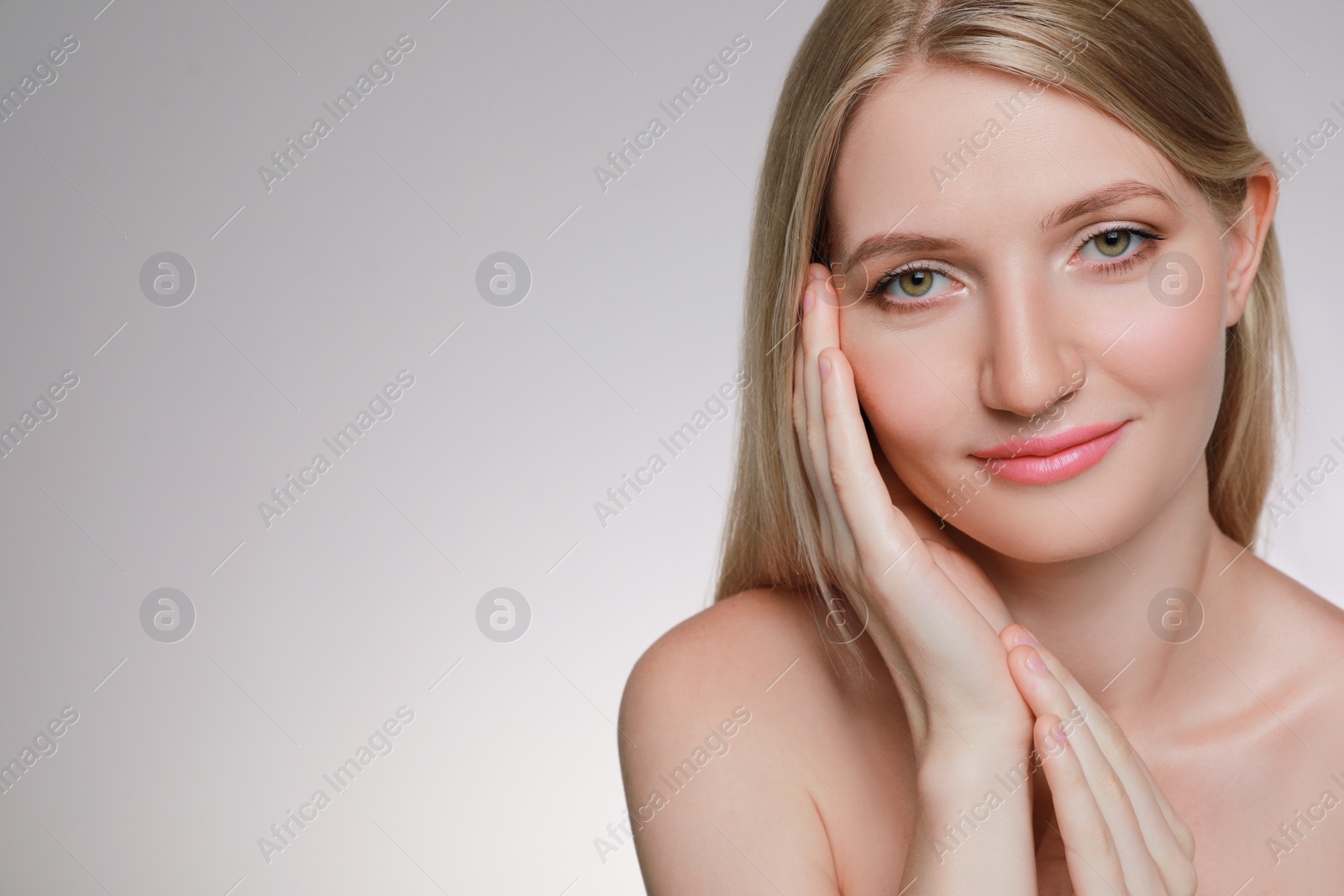 Photo of Portrait of young woman with beautiful face on beige background. Space for text