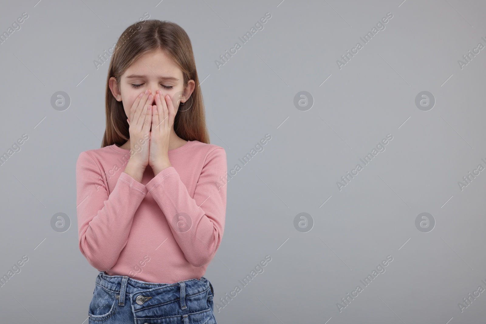 Photo of Sick girl coughing on gray background, space for text