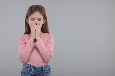 Sick girl coughing on gray background, space for text