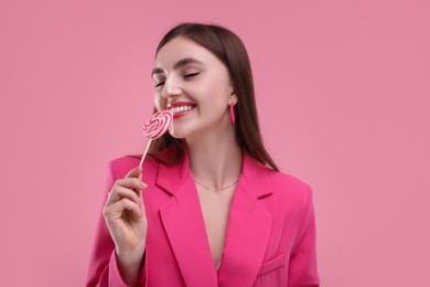 Photo of Pink look. Beautiful woman with lollipop on color background