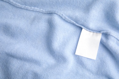 Photo of Warm light blue cashmere sweater with clothing label, closeup