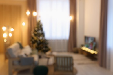 Photo of TV set, furniture and Christmas tree in stylish room, blurred view