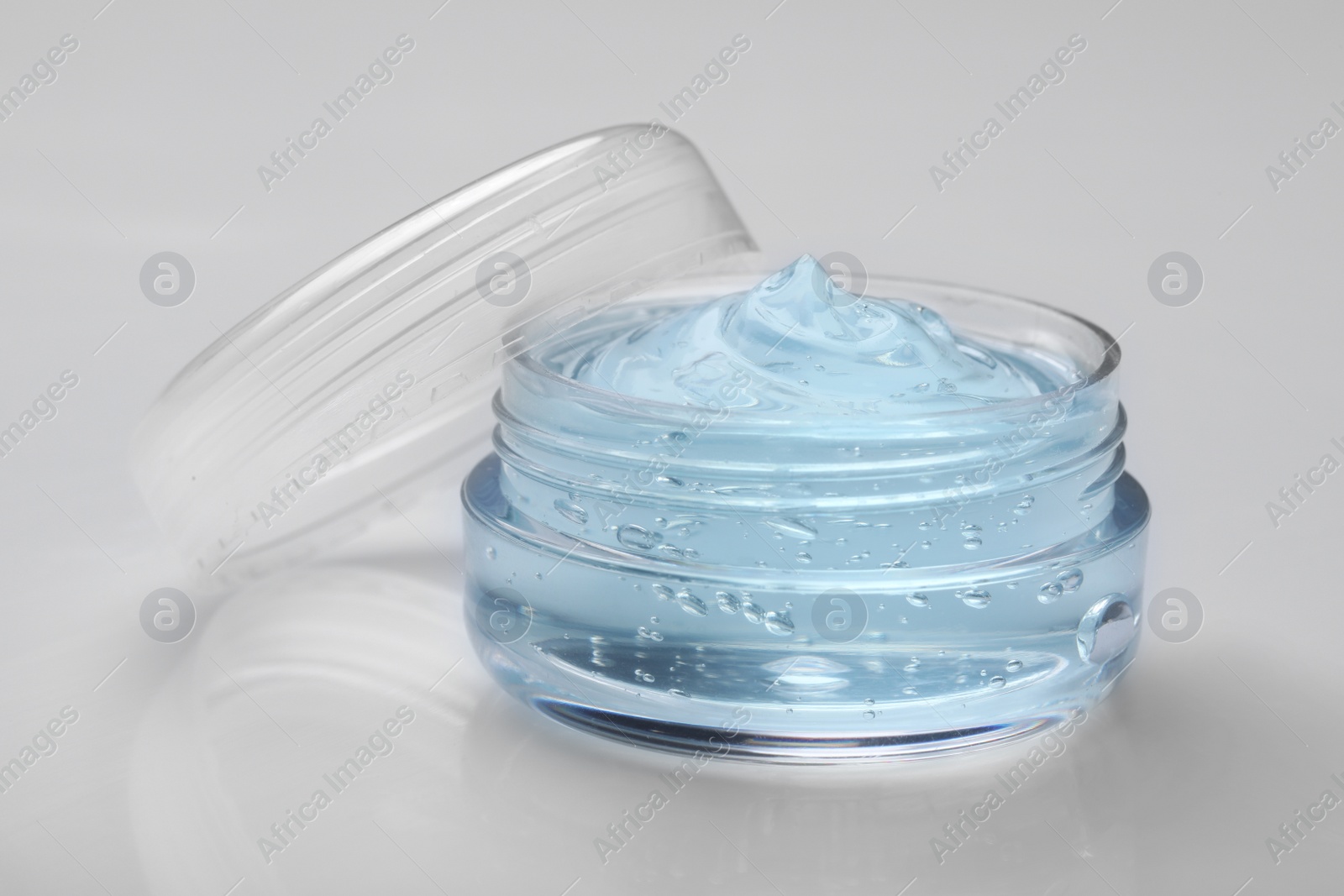 Photo of Jar of transparent cosmetic gel on light background