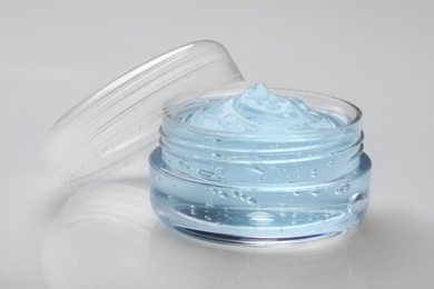 Photo of Jar of transparent cosmetic gel on light background