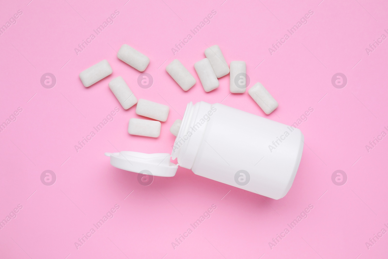 Photo of Jar with chewing gums on pink background, flat lay