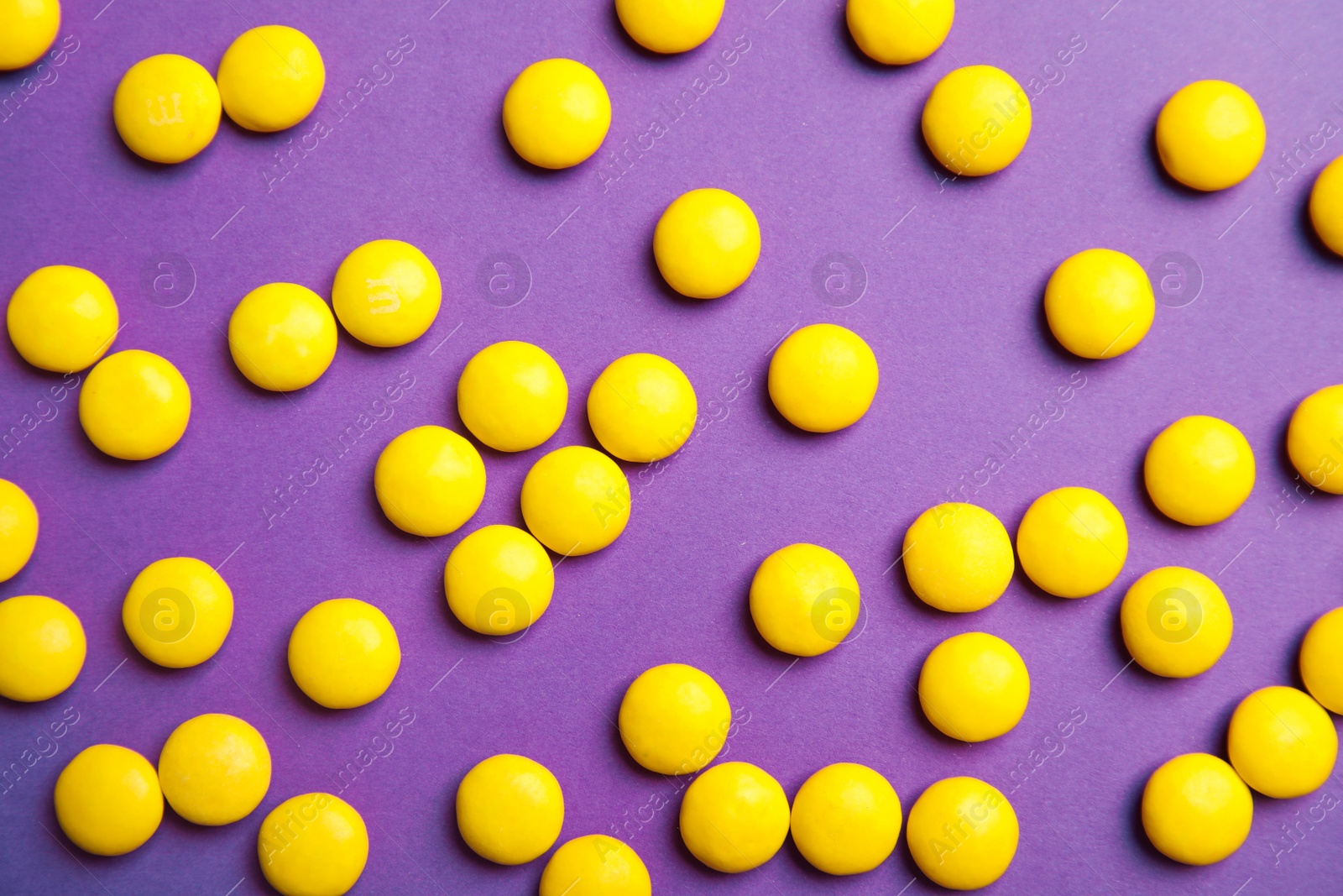 Photo of Tasty glazed candies on color background, top view