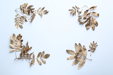 Photo of Frame made of golden rowan leaves and berries on white background, flat lay with space for text. Autumn season