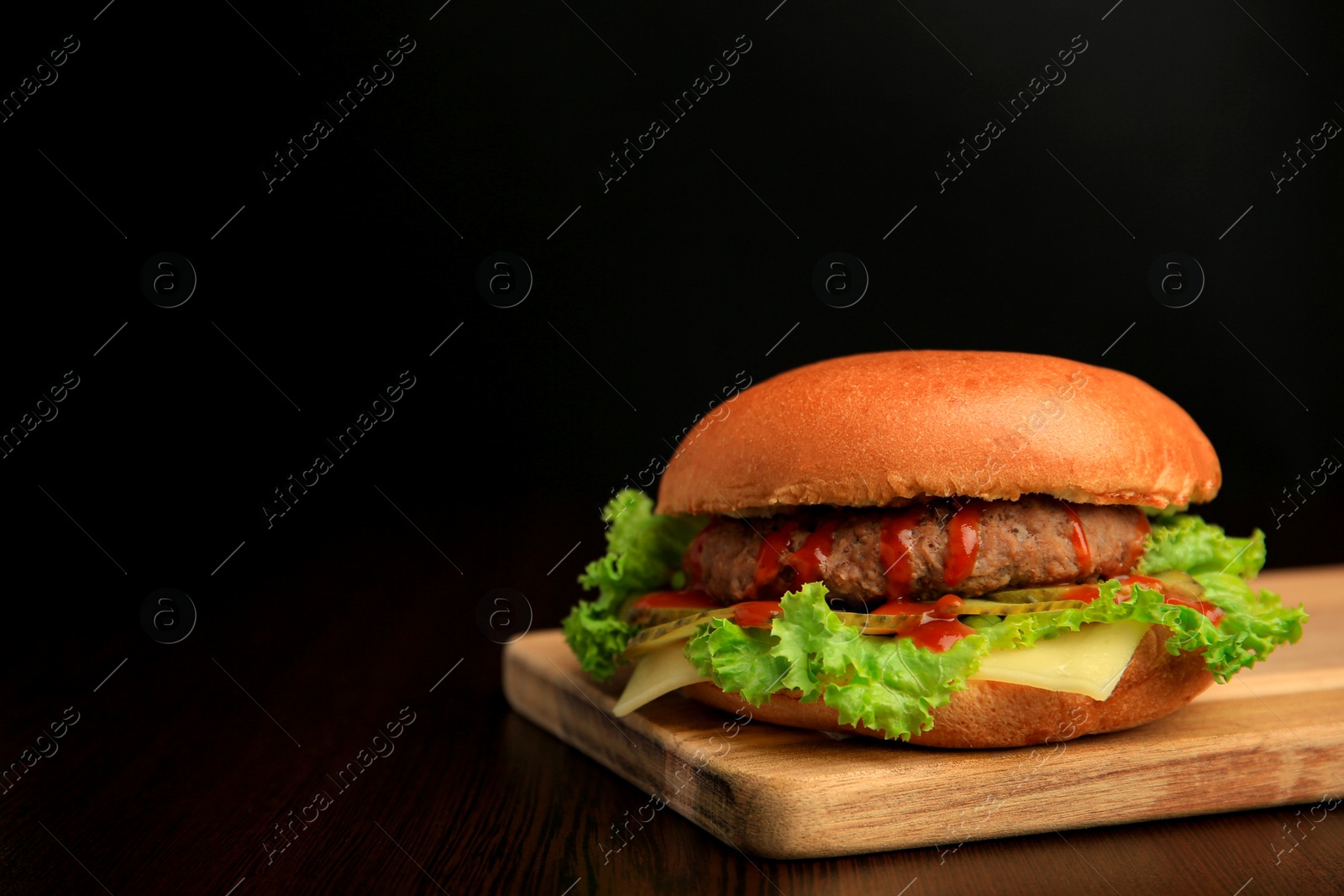 Photo of One tasty burger with patty, lettuce and cheese on wooden table, space for text