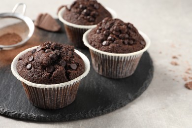 Delicious chocolate muffins on light table, closeup