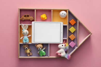 Modern tablet and kid's toys on pink background, flat lay. Space for text