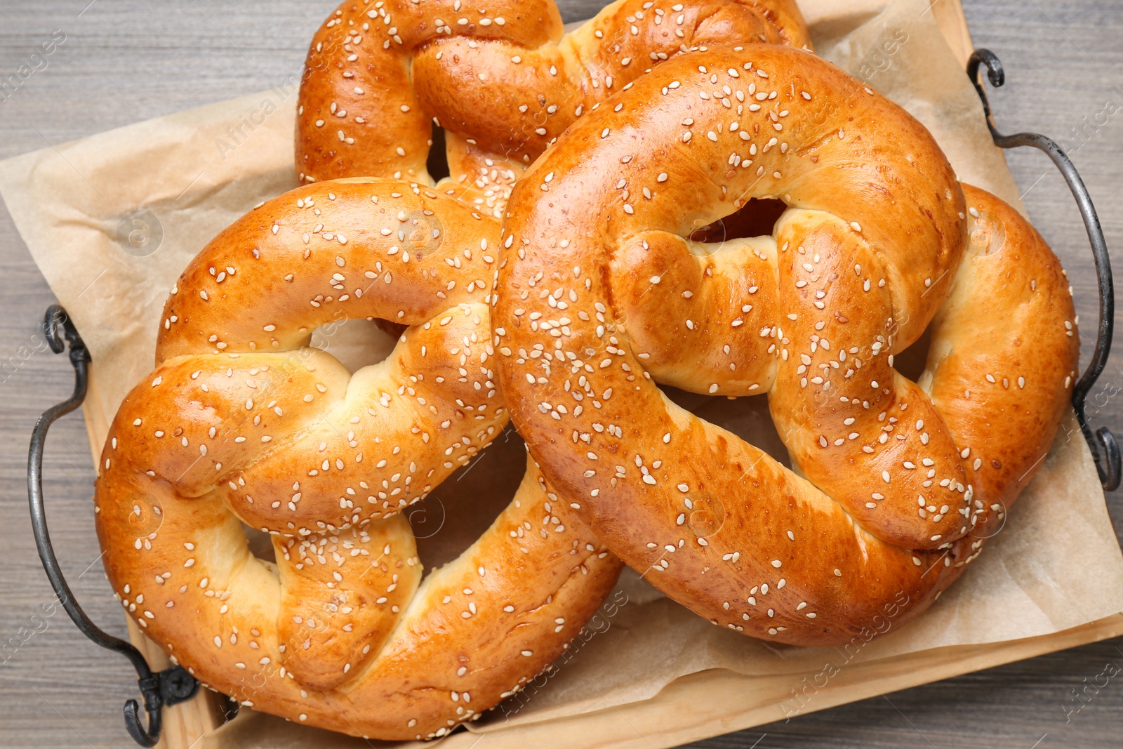 Photo of Tray with delicious pretzels on wooden table, top view