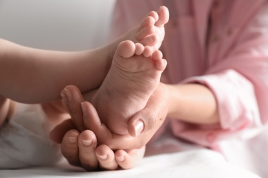 Photo of Mother holding her baby, closeup on feet