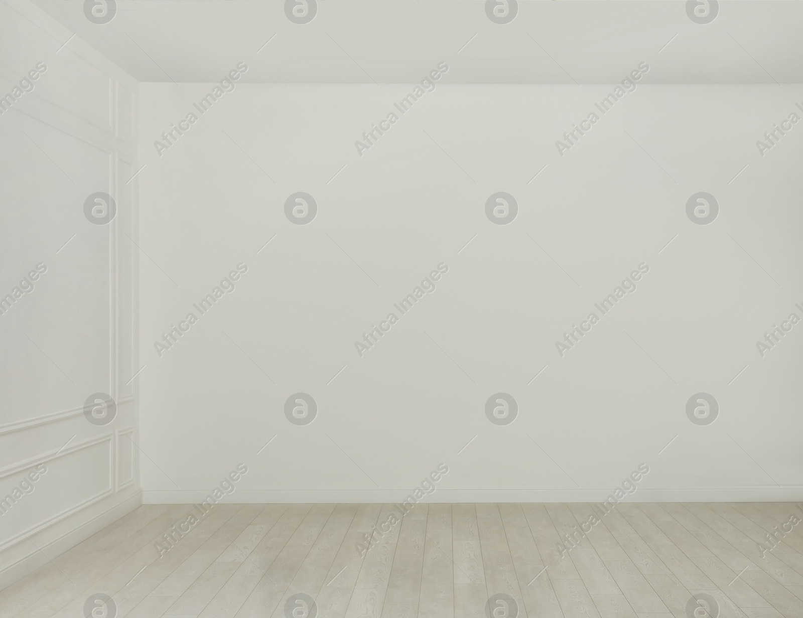 Photo of Empty room with white walls and laminated flooring