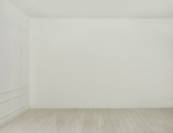 Empty room with white walls and laminated flooring