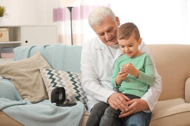 Photo of Doctor and little patient with digital glucose meter at home. Diabetes control