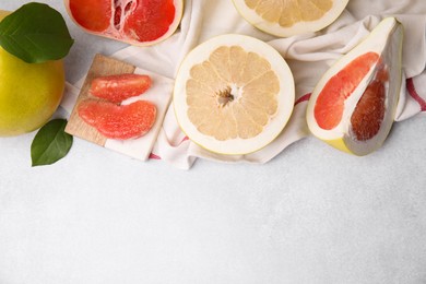 Photo of Different sorts of tasty pomelo fruits on white textured table, flat lay. Space for text