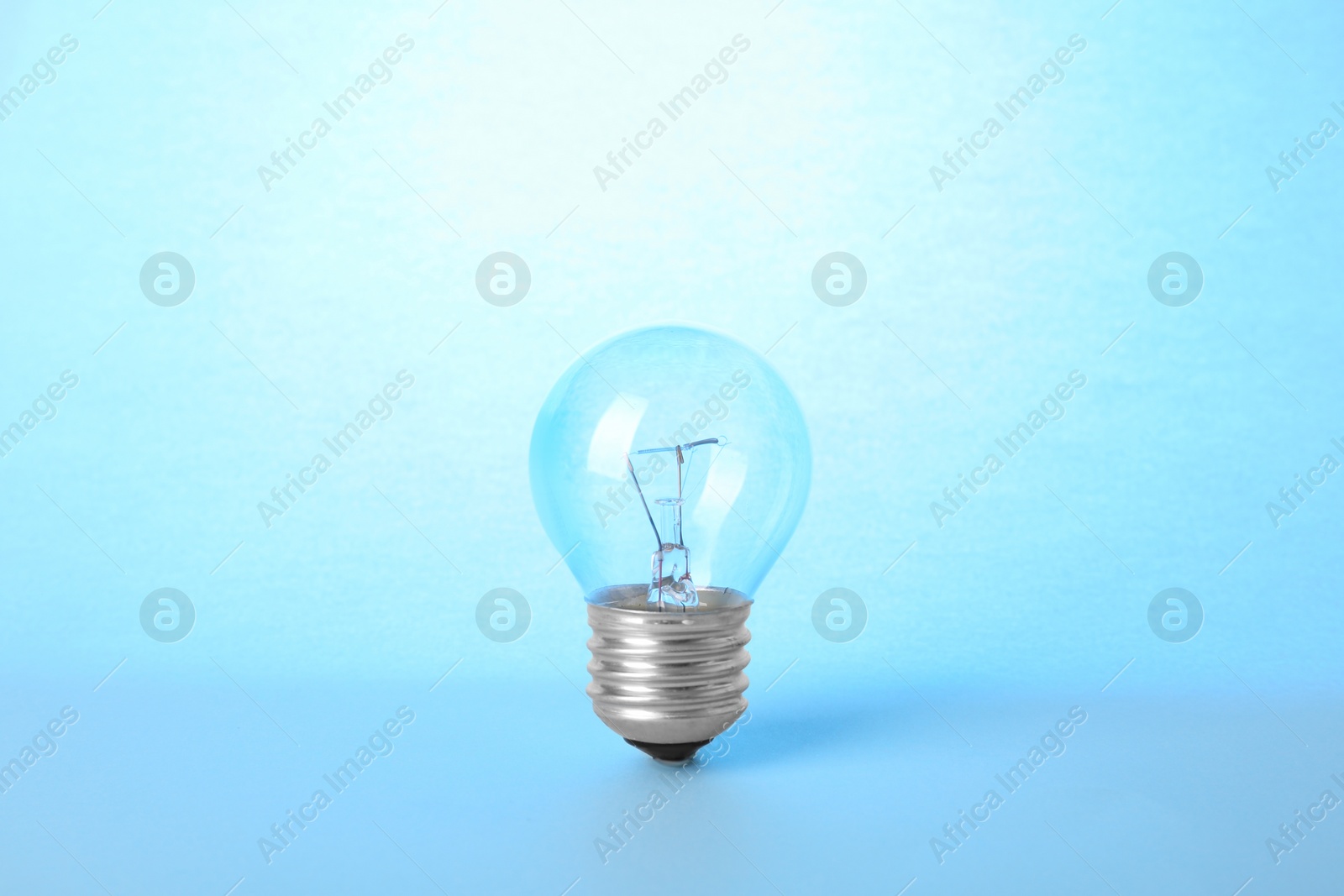 Photo of New modern lamp bulb on light blue background