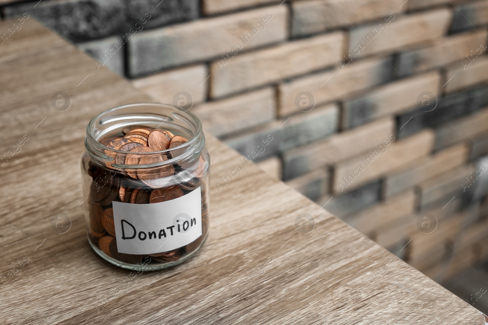 Photo of Donation jar with coins on table. Space for text