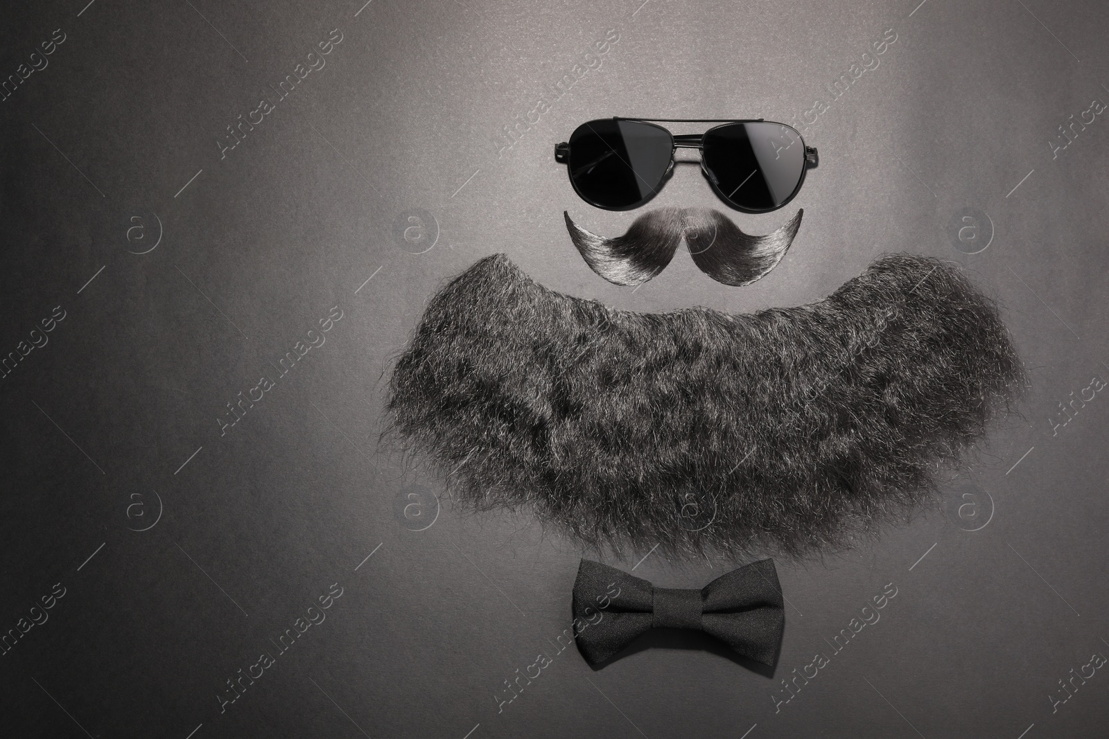 Photo of Flat lay composition with artificial moustache and sunglasses on black background, space for text