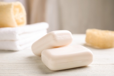 Photo of Soap bars on white wooden table indoors. Personal hygiene