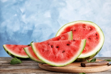 Photo of Wooden board with juicy watermelon slices on table