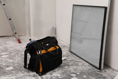 Photo of Bag tool and double glazing window on floor indoors