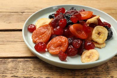 Photo of Mix of delicious dried fruits on wooden table, closeup