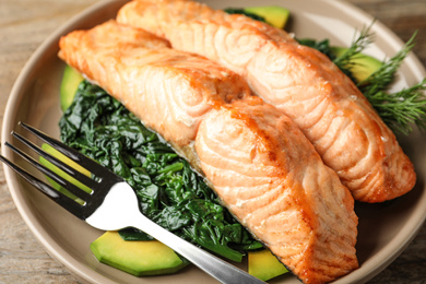 Photo of Tasty salmon with spinach and avocado on table, closeup