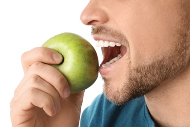 Man with perfect teeth and green apple on white background, closeup