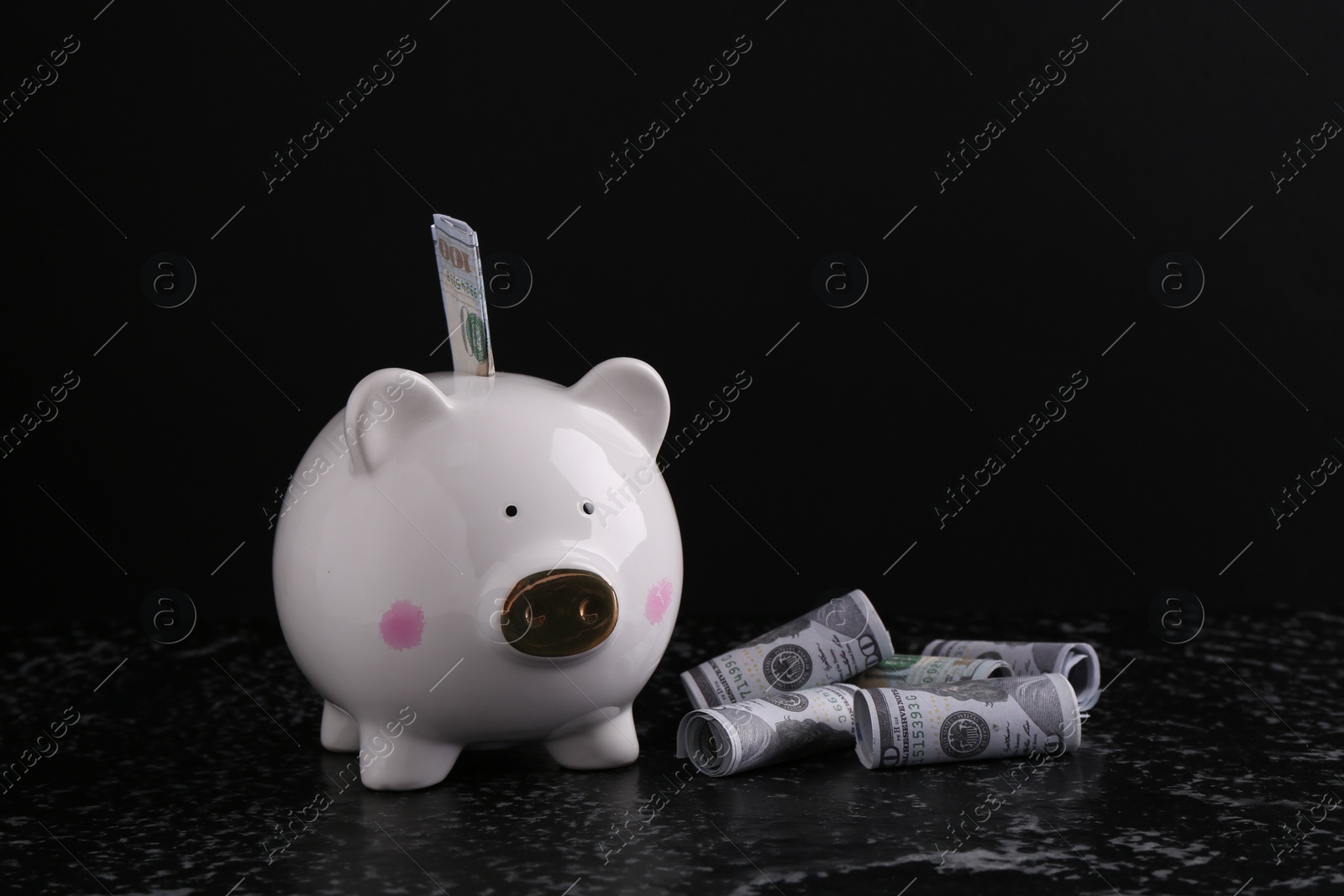 Photo of Financial savings. Piggy bank and dollar banknotes on black textured table