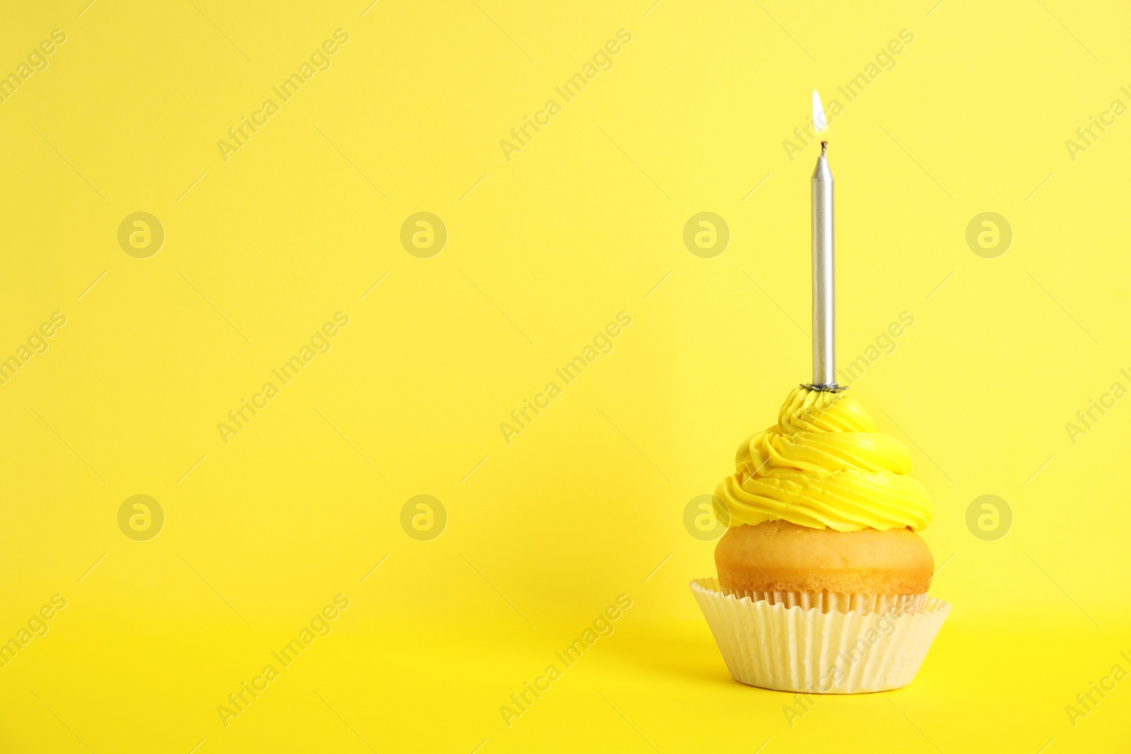 Photo of Birthday cupcake with candle on yellow background, space for text