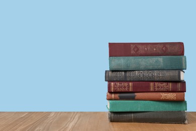 Stack of old books on wooden table, space for text