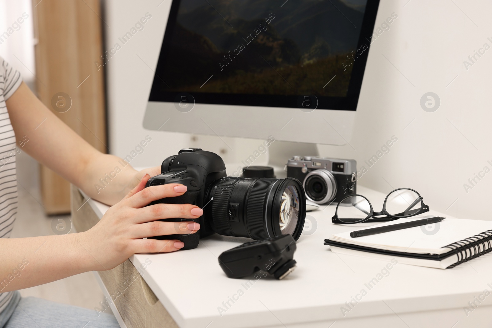 Photo of Photographer with camera at white table indoors, closeup