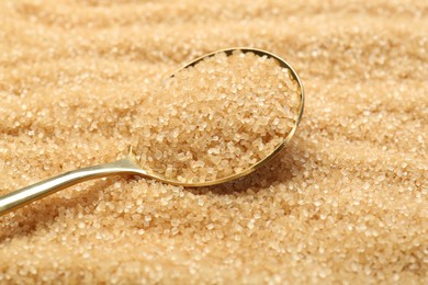 Photo of Spoon on granulated brown sugar, closeup view