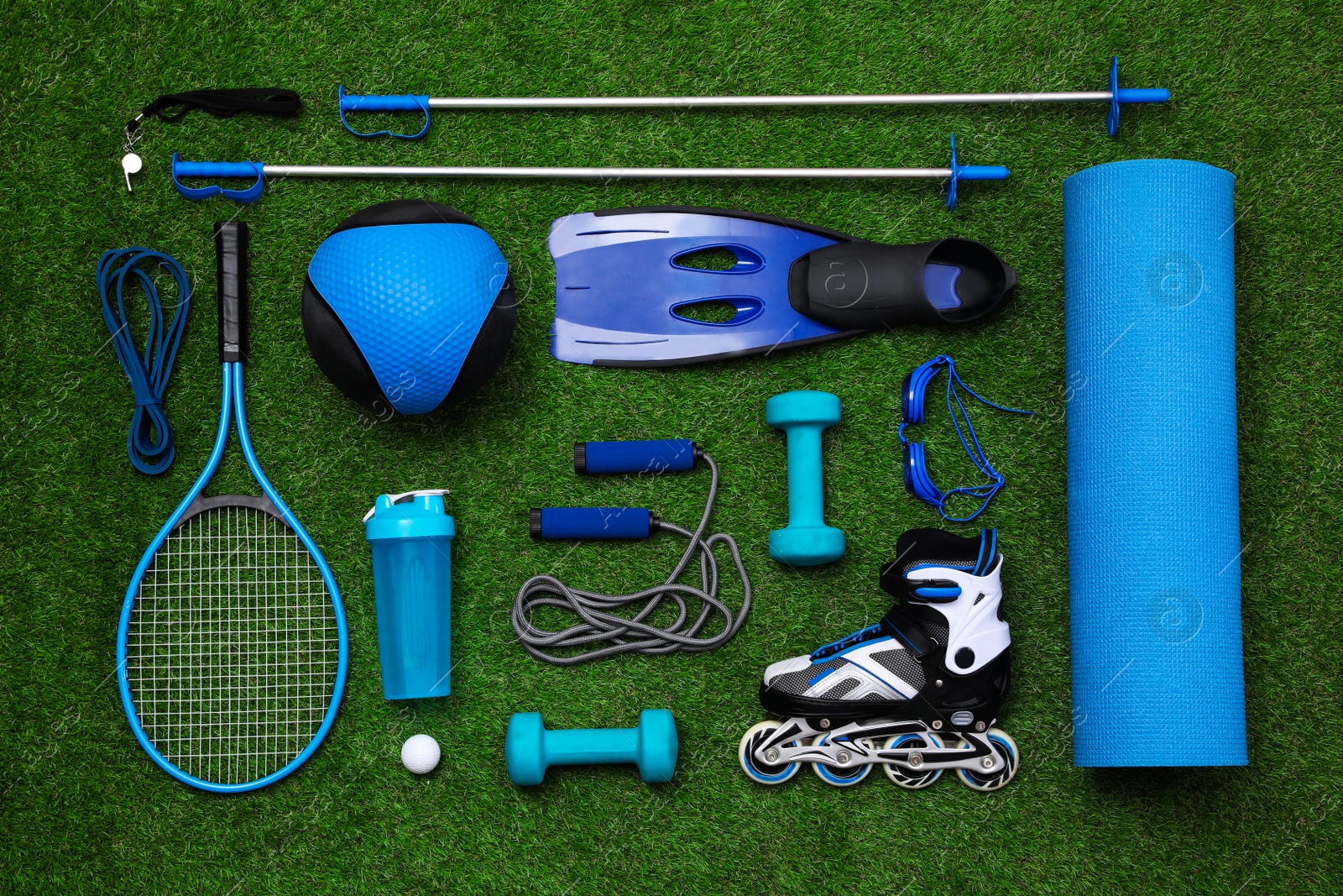 Photo of Different sport equipment on green grass, flat lay