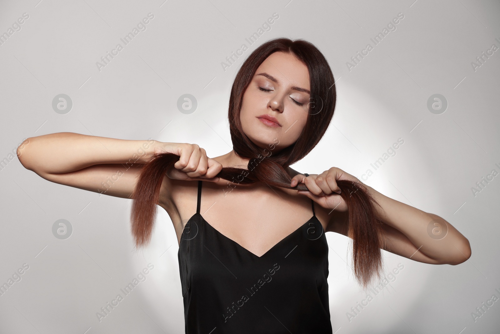 Photo of Beautiful young woman with healthy strong hair posing in studio