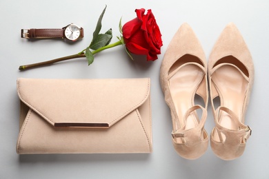 Photo of Stylish shoes, flower and accessories on light grey background, flat lay