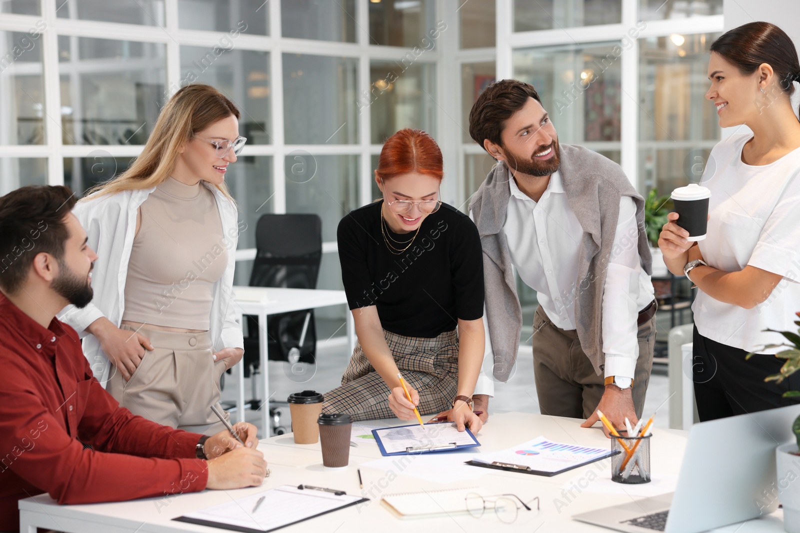 Photo of Team of employees working together in office