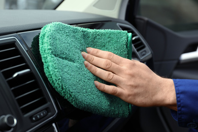 Car wash worker cleaning automobile interior, closeup