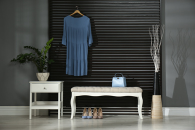 Photo of Hallway interior with bench, clothes and little cabinet